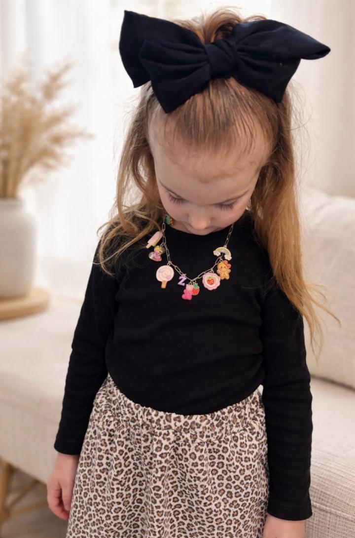 A young girl is wearing a custom made charm necklace. A young girl is wearing a custom made charm necklace.